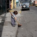 child sweeping sidewalk